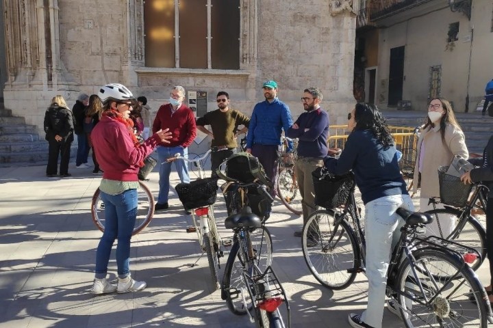 a group of people riding on the back of a bicycle