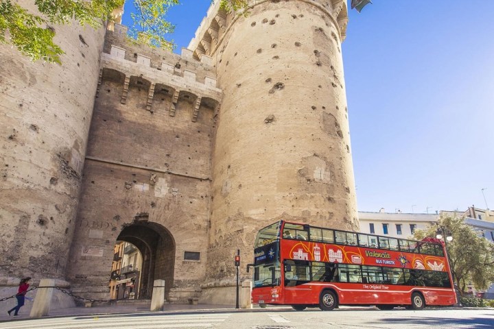 a double decker bus parked in front of a tower